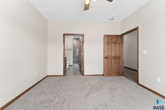 unfurnished bedroom with a closet, ceiling fan, light colored carpet, and ensuite bathroom