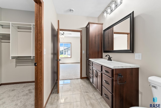 bathroom featuring vanity, toilet, ceiling fan, and tile patterned floors