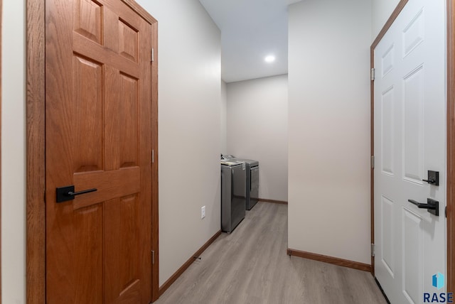 corridor featuring light wood-type flooring and independent washer and dryer