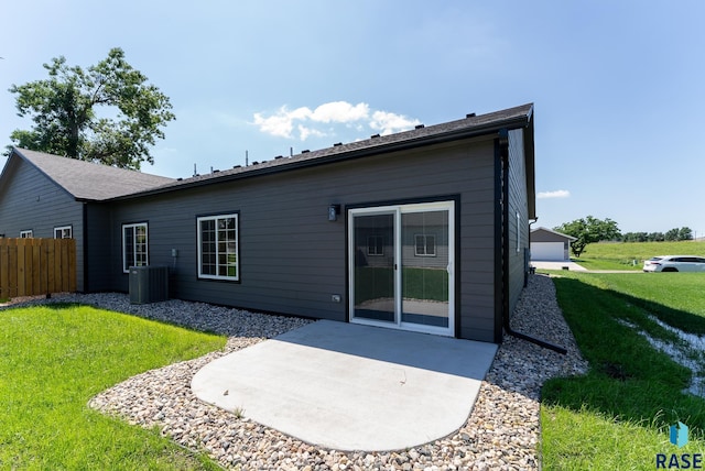 rear view of house with a lawn, a patio area, and central air condition unit