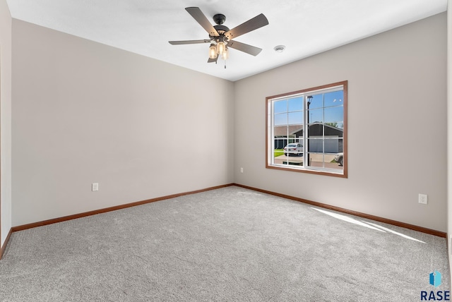 carpeted spare room featuring ceiling fan