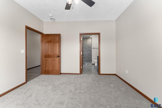 unfurnished bedroom featuring ceiling fan, light colored carpet, and connected bathroom