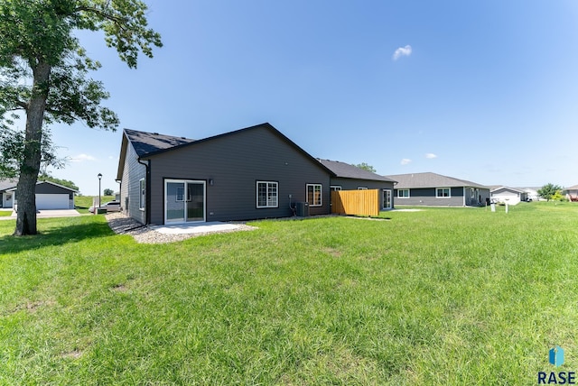 back of house with central AC unit, a lawn, and a patio