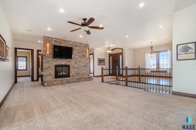 living room with ceiling fan, light colored carpet, and a fireplace