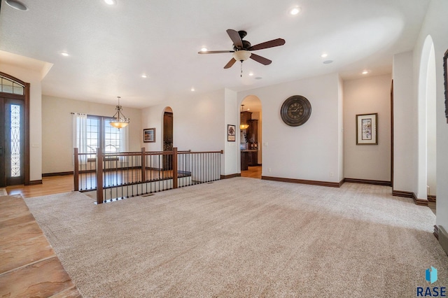 unfurnished living room with ceiling fan and light colored carpet