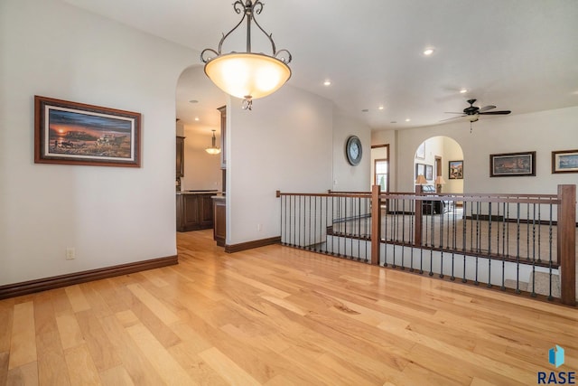 empty room with ceiling fan and light wood-type flooring