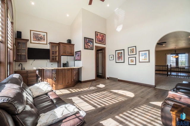 living room featuring ceiling fan, hardwood / wood-style floors, and high vaulted ceiling