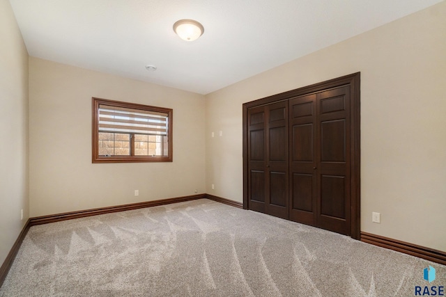 unfurnished bedroom with light carpet and a closet