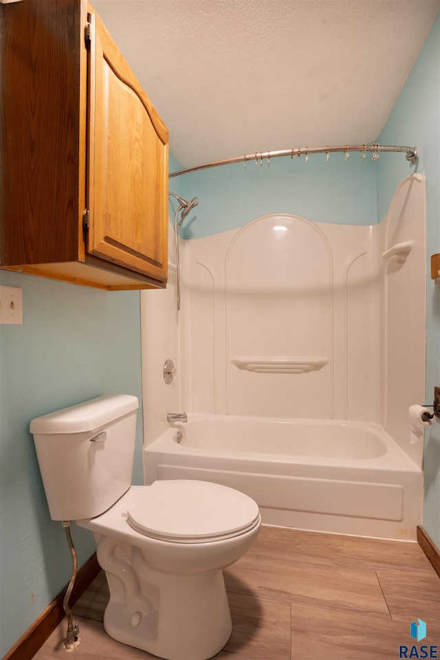 bathroom featuring shower / tub combination, hardwood / wood-style floors, and toilet