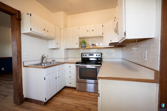 kitchen featuring sink, white cabinetry, stainless steel electric range oven, light hardwood / wood-style flooring, and decorative backsplash