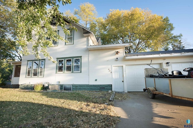 back of property with a garage and a yard