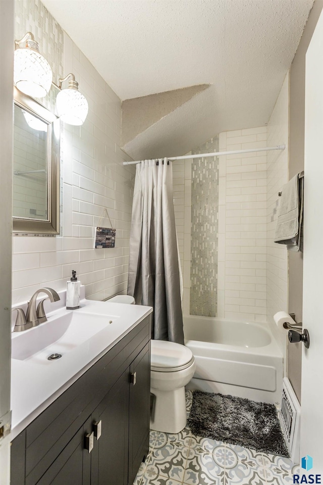 full bathroom featuring tile walls, shower / bath combo with shower curtain, vanity, a textured ceiling, and toilet