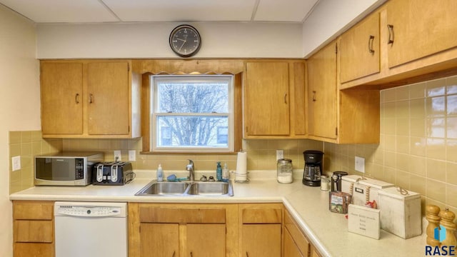 kitchen with backsplash, dishwasher, and sink