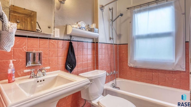 full bathroom featuring sink, tile walls, bathing tub / shower combination, and toilet