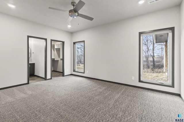 unfurnished bedroom featuring carpet floors, baseboards, and multiple windows