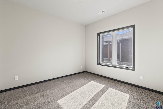 spare room featuring visible vents, carpet flooring, and baseboards
