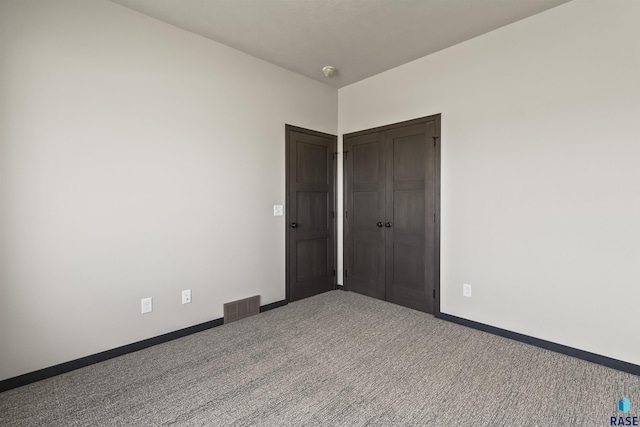 unfurnished bedroom featuring baseboards, visible vents, and carpet floors