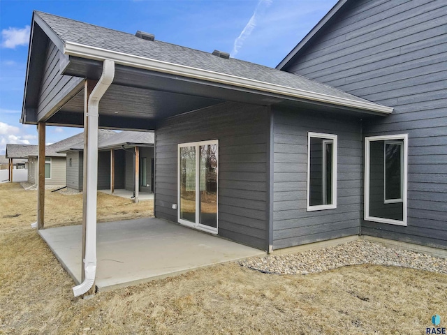 back of house featuring a shingled roof and a patio