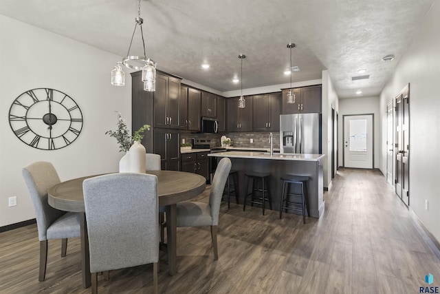 dining area featuring recessed lighting, baseboards, and dark wood-style flooring