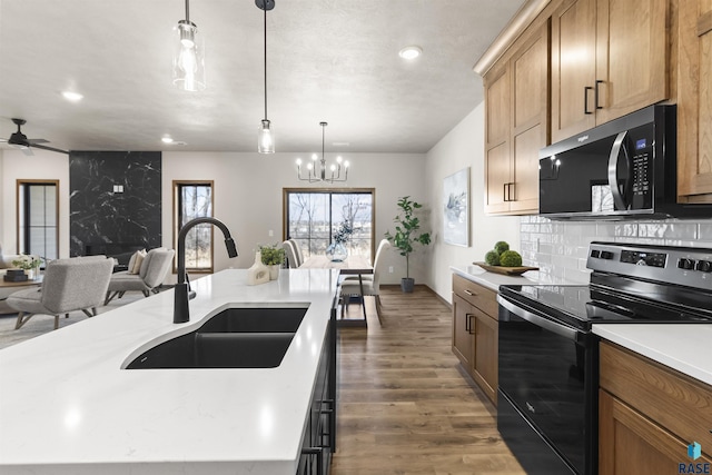 kitchen featuring electric stove, pendant lighting, light countertops, dark wood-type flooring, and a sink