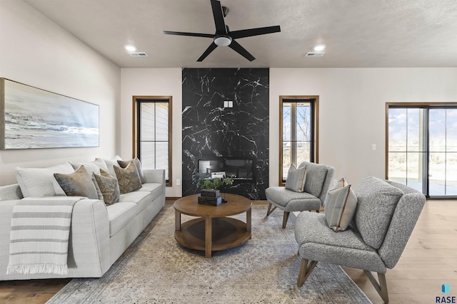 living area with a ceiling fan, visible vents, wood finished floors, and recessed lighting