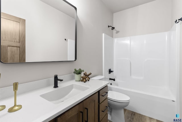 bathroom with tub / shower combination, vanity, toilet, and wood finished floors