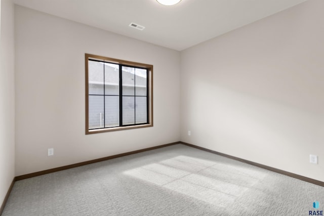 unfurnished room with carpet, visible vents, and baseboards