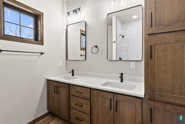 full bath with double vanity, a sink, and baseboards