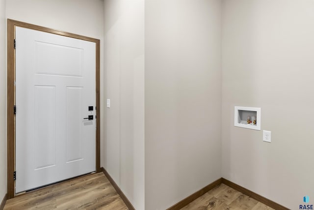 interior space featuring hookup for a washing machine, laundry area, light wood-style flooring, and baseboards