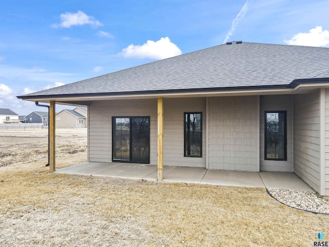 rear view of property featuring a shingled roof