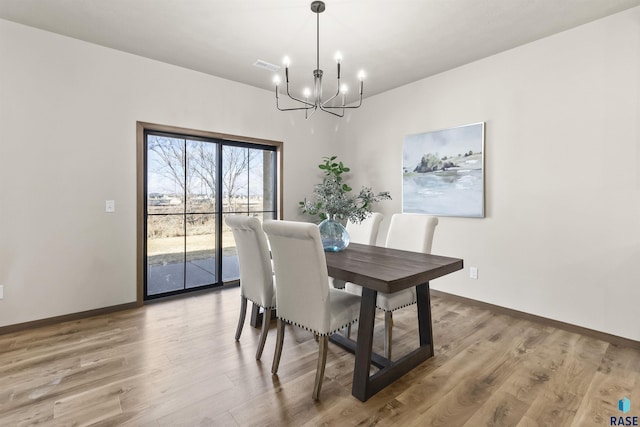 dining space featuring a chandelier, visible vents, baseboards, and wood finished floors