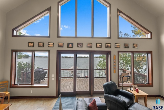 interior space featuring high vaulted ceiling, plenty of natural light, and a water view