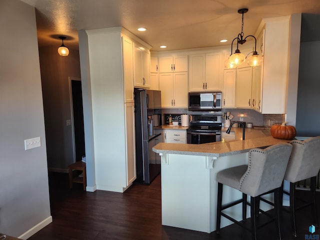 kitchen featuring white cabinetry, backsplash, pendant lighting, black appliances, and dark hardwood / wood-style floors