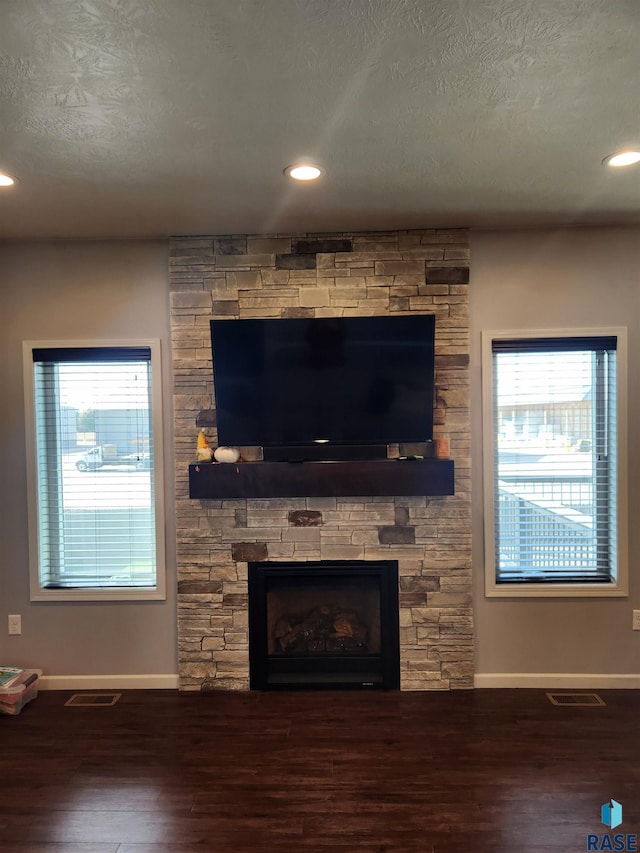 interior details featuring a textured ceiling, a fireplace, and hardwood / wood-style floors