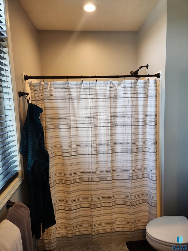 bathroom featuring curtained shower and toilet