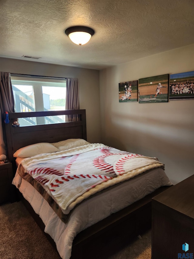 bedroom with a textured ceiling and carpet