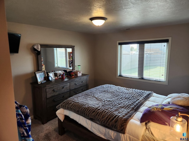 bedroom featuring a textured ceiling and carpet