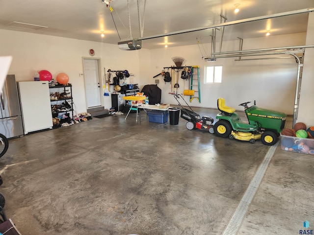 garage featuring a garage door opener, stainless steel fridge, and white fridge