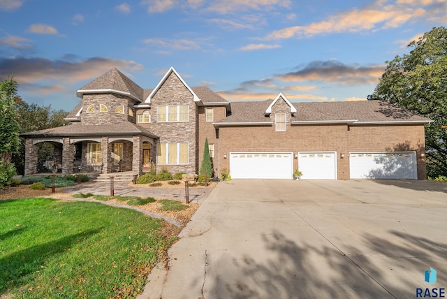 view of front of house featuring a garage, a porch, and a yard