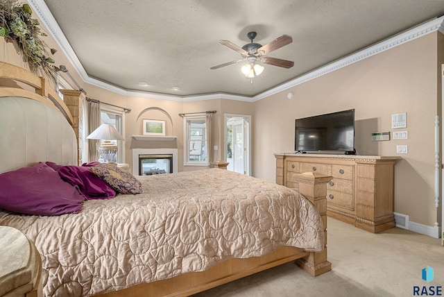 bedroom featuring ornamental molding, ceiling fan, light colored carpet, and a textured ceiling