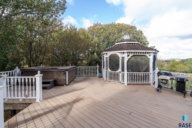 wooden terrace featuring a gazebo and a hot tub