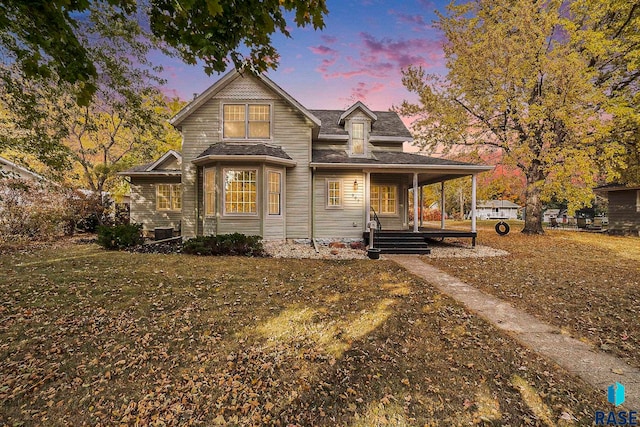 view of front of home with covered porch and a lawn