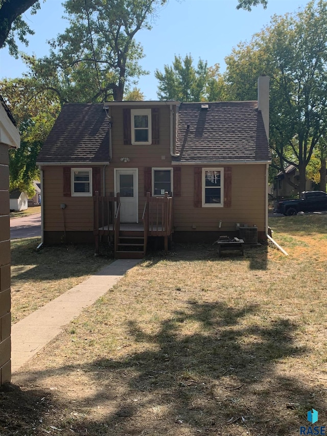 view of front facade with a front yard and central AC unit