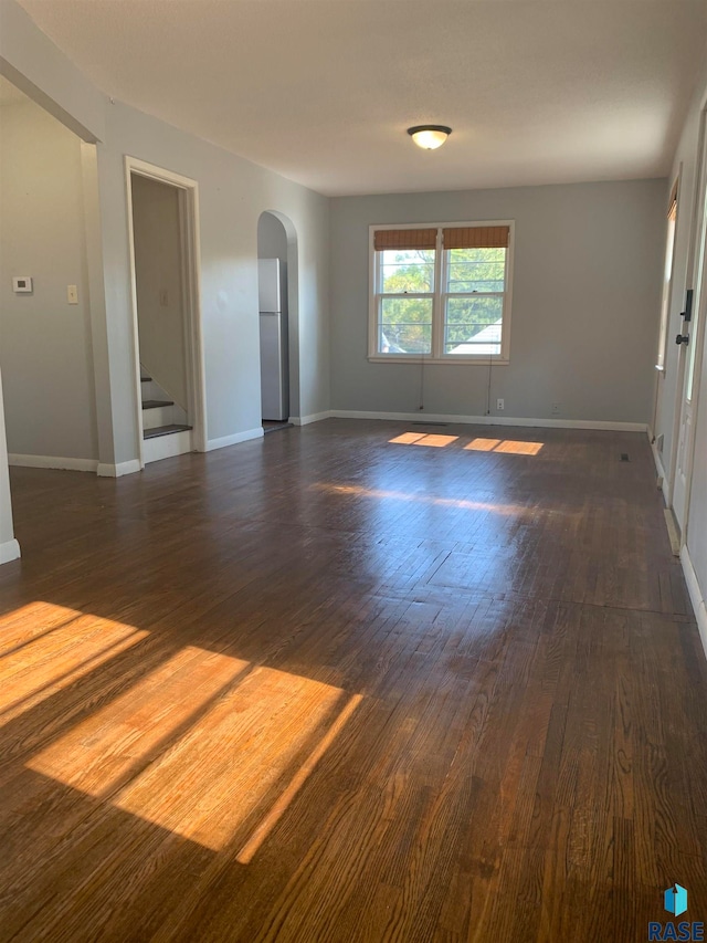 unfurnished room with dark hardwood / wood-style flooring