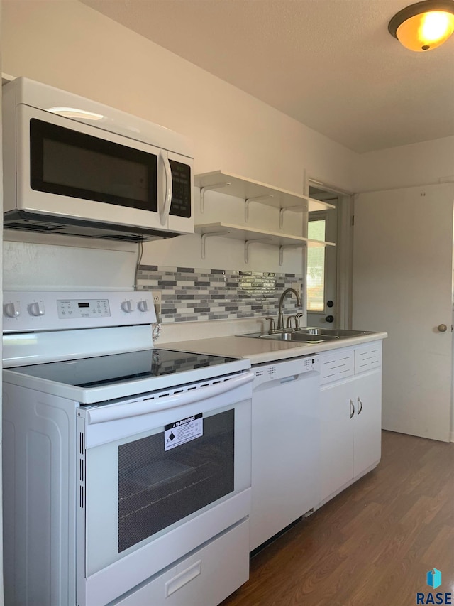 kitchen with dark wood-type flooring, white appliances, white cabinets, and sink