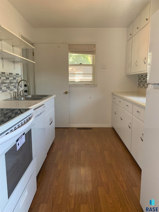 kitchen featuring white appliances, backsplash, and white cabinets