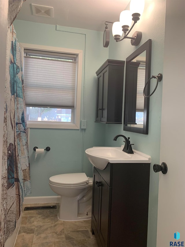 bathroom featuring a notable chandelier, toilet, walk in shower, and vanity