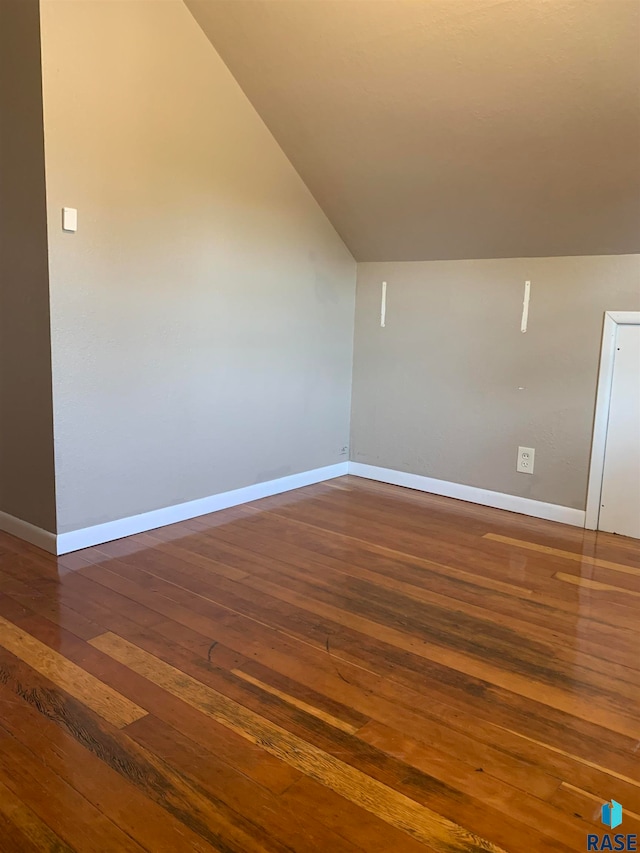 additional living space with vaulted ceiling and dark wood-type flooring