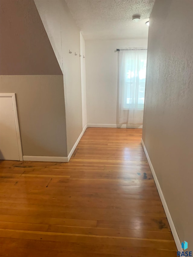 hall featuring hardwood / wood-style flooring and a textured ceiling