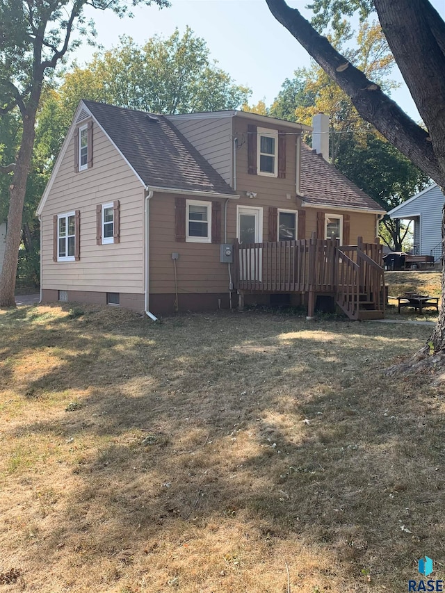 rear view of property featuring a yard and a deck